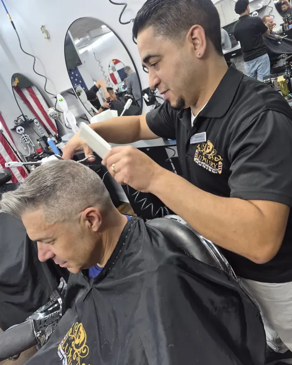 Barber trimming a client's gray hair at Dominican Luxury Gentleman Salon