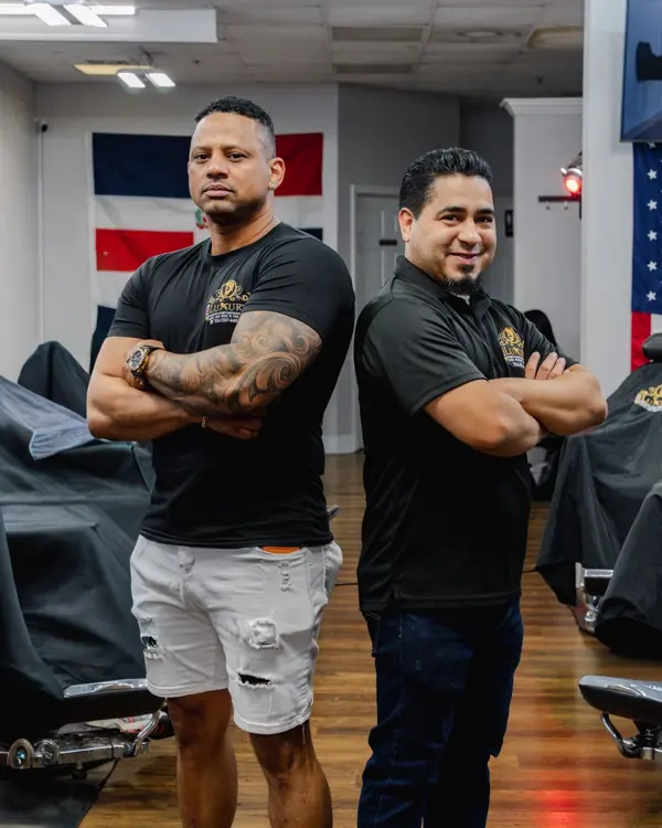 Two barbers from the shop standing together in the barbershop