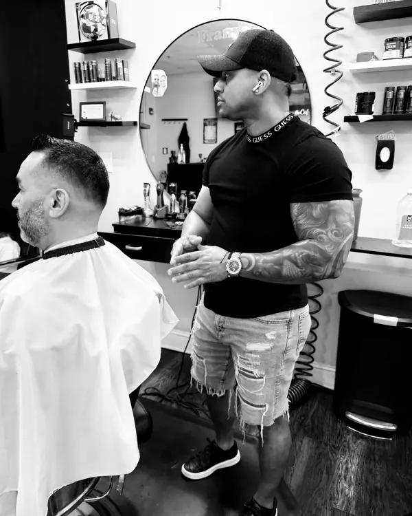 Barber standing beside a client in the chair