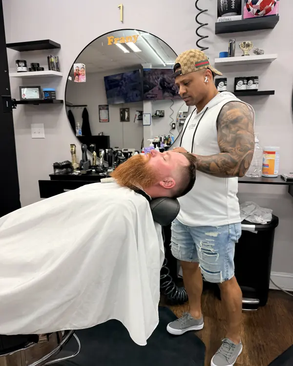 Barber giving a client a beard treatment